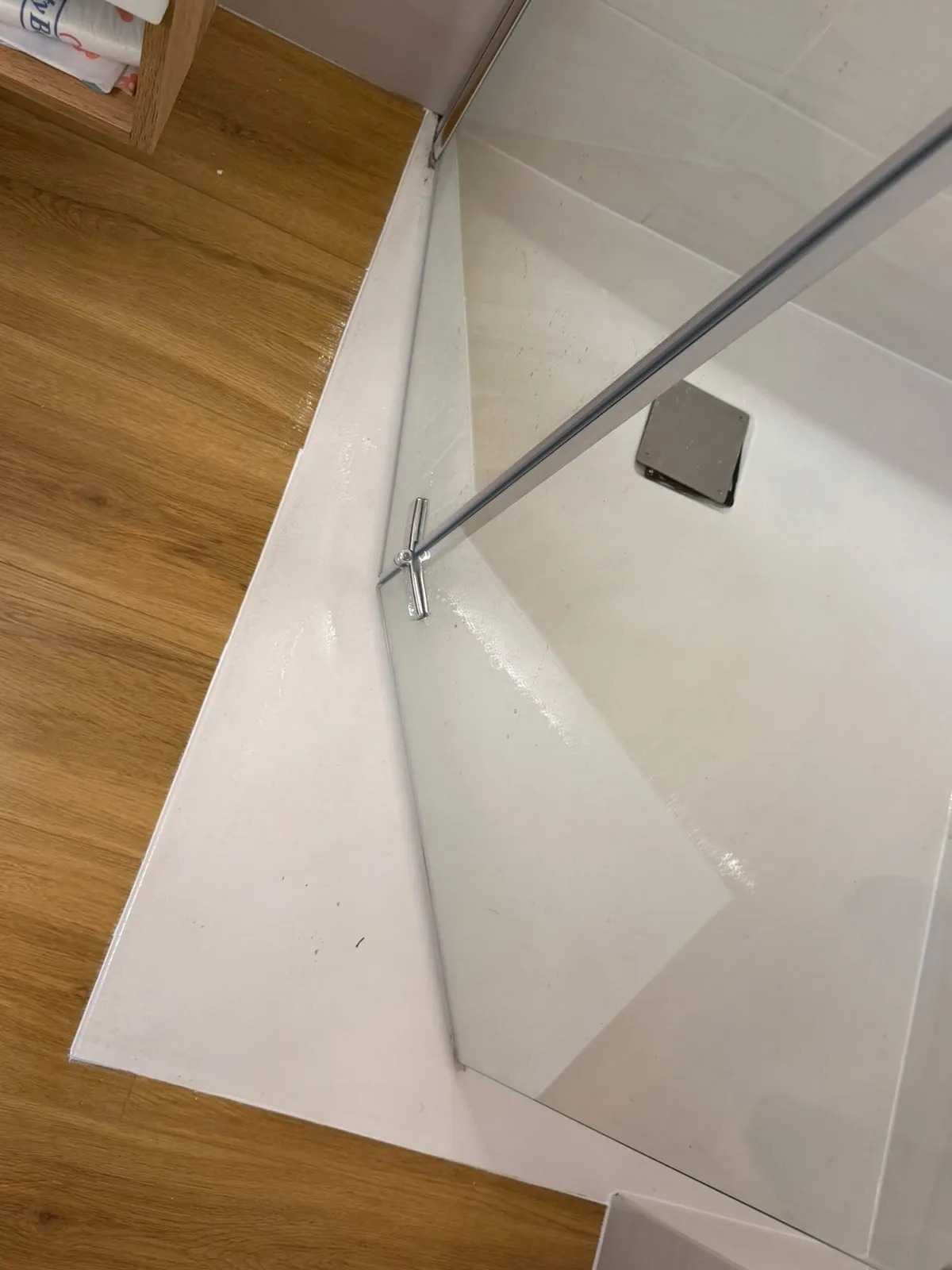 Erneuerte Silikonfuge am Anschluss zur Glaswand einer Walk-in-Dusche