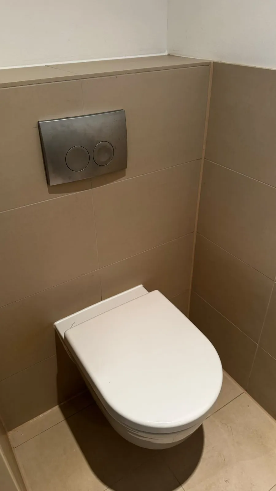 Erneuerte Silikon-Anschlussfugen am WC mit beigen Fliesen